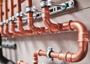 Copper plumbing pipes with metal clamps